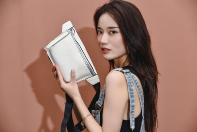 服饰系列写实风模特拿着白色单肩包展示的摆拍