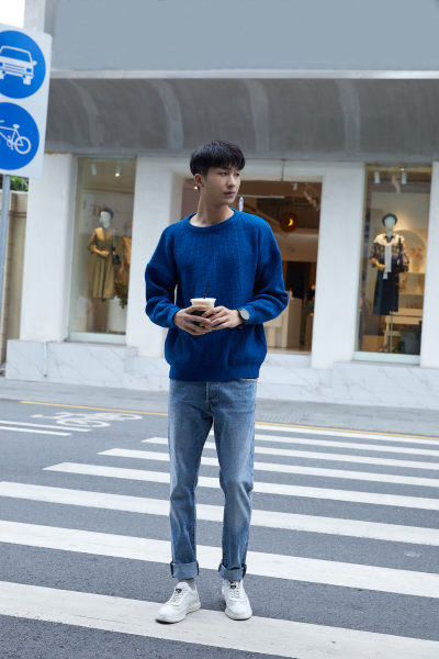 服饰系列实景模特穿着灰色卫衣和蓝色牛仔裤的街头摆拍 
