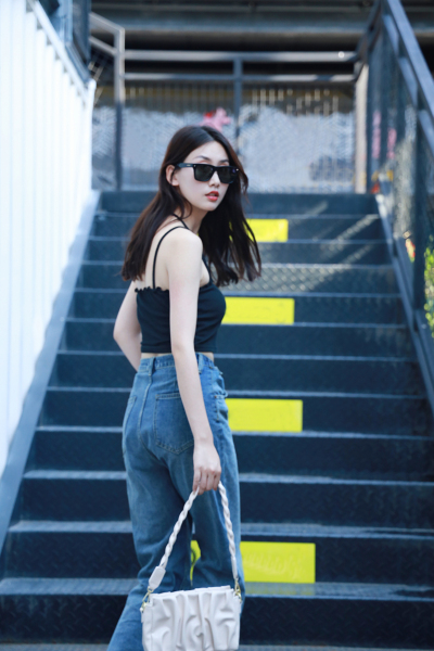 人物系列写实穿着时尚的年轻女性站在楼梯上的侧面街拍半身照