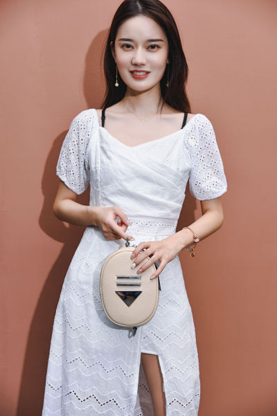 服饰系列写实风模特拿着杏色包包展示的摆拍