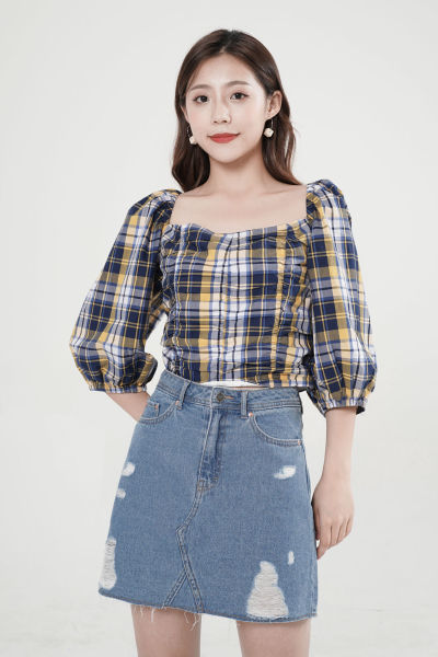 服饰系列写实模特穿着黑白黄格子一字肩上衣和蓝色短裙的摆拍