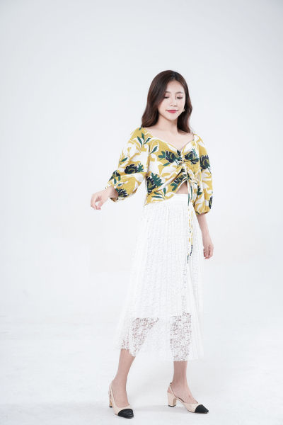 服饰系列写实模特穿着黄绿色V领上衣和白色半身长裙的白棚摆拍