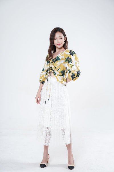 服饰系列写实模特穿着黄绿色V领上衣和白色半身长裙的白棚摆拍