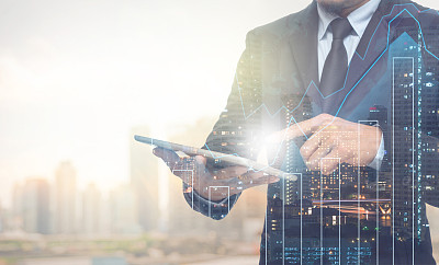 Double exposure of businessman using the tablet with cityscape
