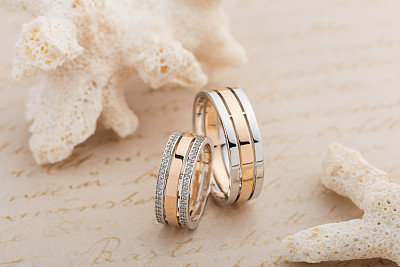 Pair of pink gold and white gold wedding ring with diamonds on female ring