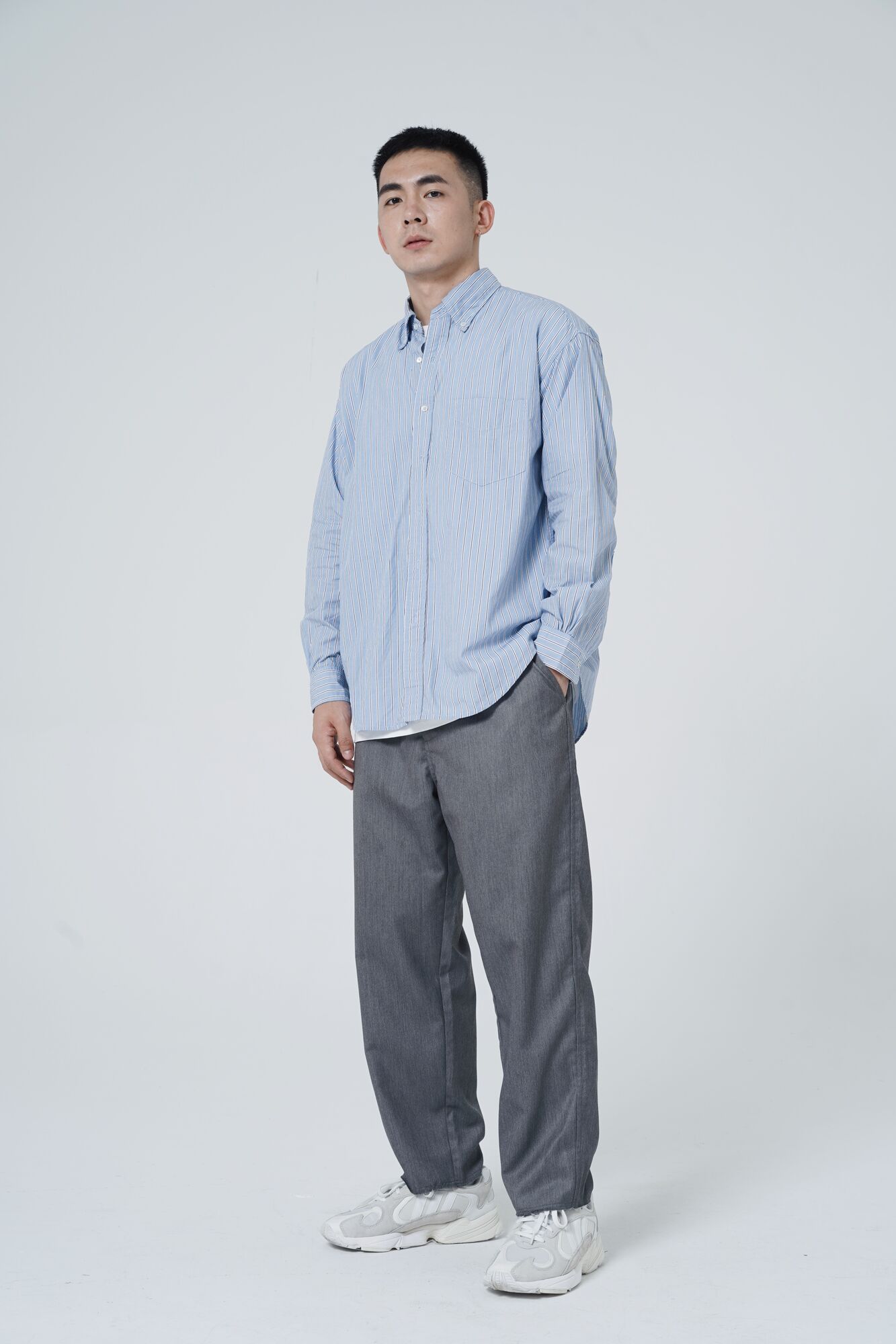 服饰系列实景模特穿着蓝色条纹衬衫和灰色西装裤