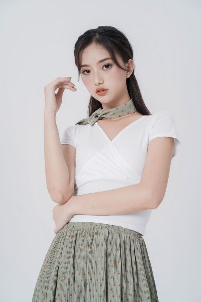 服饰系列实景模特穿着白色交襟短袖上衣和豆绿色百褶半裙