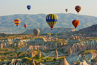 Colorful hot air balloons flying over the valley at Cappadocia,