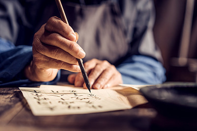 Chinese senior man writing chinese calligraphy