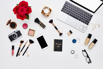 Flat lay of beauty products and technology on bloggers desk