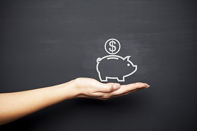 Human hand holding piggy bank