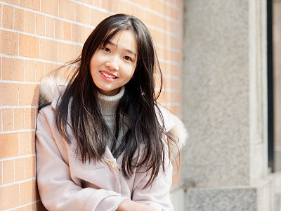 Portrait of beautiful young brunette woman in white winter fluffy coat. Outdoor fashion glamour Chinese teenage stylish lady. Emotions, people, beauty and lifestyle concept.