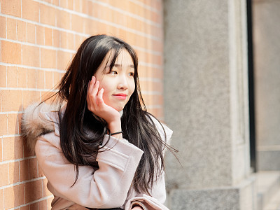 Portrait of beautiful young brunette woman in white winter fluffy coat. Outdoor fashion glamour Chinese teenage stylish lady. Emotions, people, beauty and lifestyle concept.