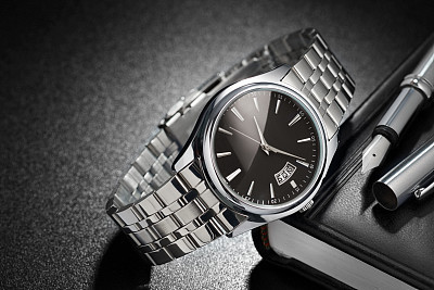 Steel wristwatch on black background