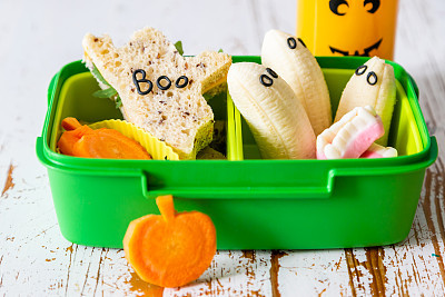 Halloween style school lunch box - ghost sandwich, pumpkin carrots, bananas, juice