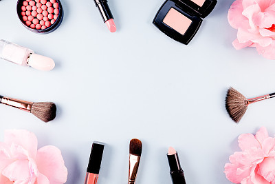 Beauty background makeup cosmetic product,with green leaf and pink rose blossom on purple spring background. woman mother day concept. flatlay topview