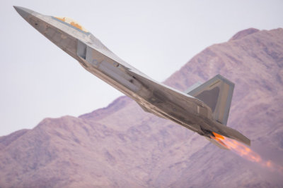 F-22 Raptor in a very close view, with afterburners on, against the Nevada hills