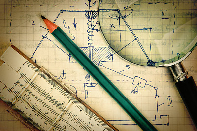 magnifying glass and a slide rule on the old page with the calculations in mechanics