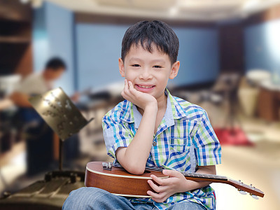 boy holding ukelele at music school