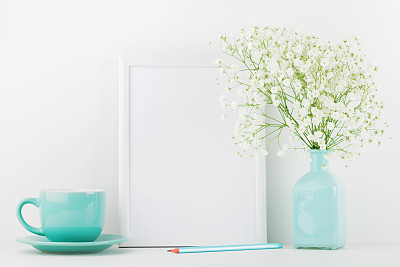 Mockup of picture frame decorated flowers in vase and coffee cup. Website design concept.