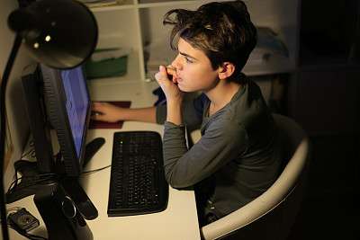 Teenager working his homework on a computer
