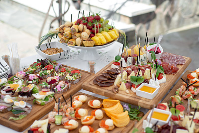 Large selection of food with cold snacks, meat and salads, fruit, cold meats, cheese and jam served. Variety of tasty delicious snacks on the table.