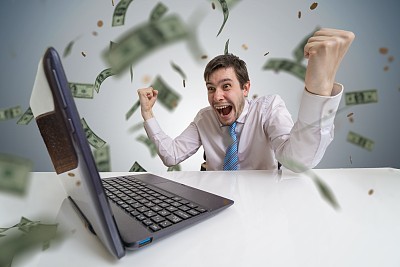 Young man wins a lottery online. Money are falling from above. Online betting concept.