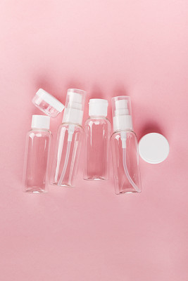 Travel small bottle set on a pink background. Top view