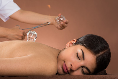 Person Holding Lit Camphor And Cup