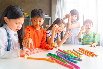 Asian kids playing with play colorful clay at home or kindergarten or playschool