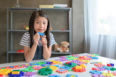 Kids playing Alphabet puzzle pieces together and having fun
