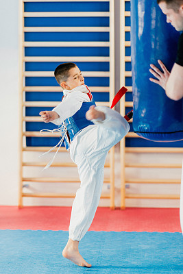Boy kicking punching bag