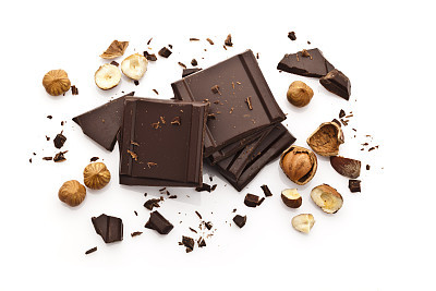 Chocolate pieces and hazelnuts isolated on white background