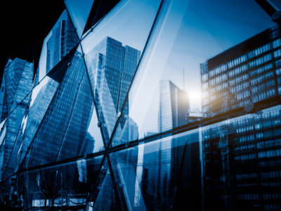 View of a modern glass skyscraper reflecting the buildings around