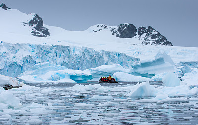 Boat with tourists floating amongst Icebergs in Antarctica