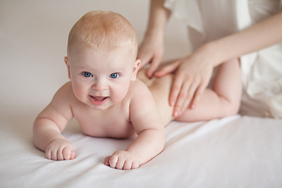Mom makes the baby massage.Baby skin care. Mother care.