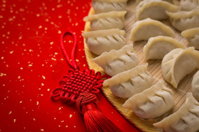 dumplings and Chinese kont on the red paper with white space