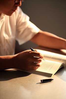 Man Reading with Pen on Hand