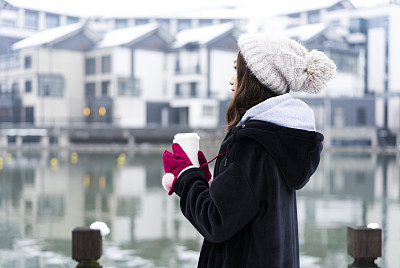 young woman with coffee standing at bridge