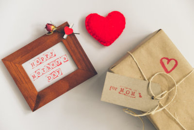 happy mother day text in wooden frame with craft gift box on white background