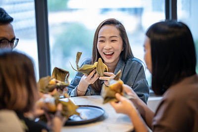 enjoying and eating 'Zongzi' or 'bakcang', 'bacang' a Chinese traditional food