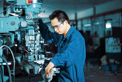 factory worker using drilling machine