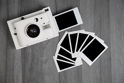 Vintage white instant camera with isolated blank photographs