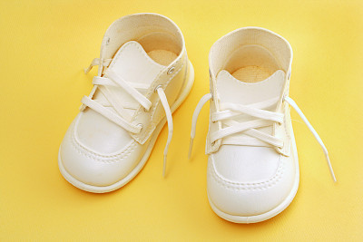 baby shoes over yellow