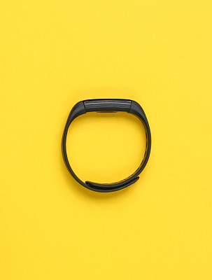 Smart bracelet, tracker isolated on a yellow background. Top view, minimalism