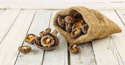 Dried shiitake mushrooms on white wood