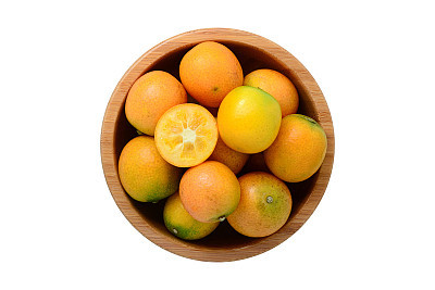 Top view for ripe kumquat fruit in wooden bowl isolated on white
