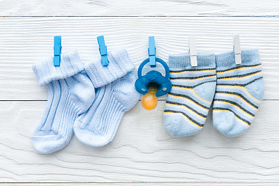 baby socks on rope at wooden background