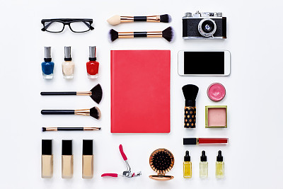 pink note book surrounded with beauty products and technologies