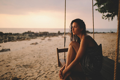 Young brunette woman on the beach of Koh Lanta island, Thailand, watching the horizon